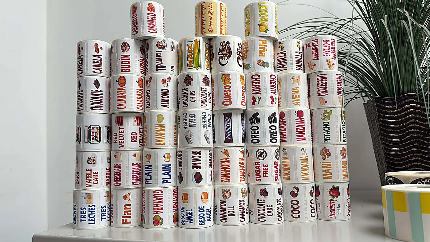 Stacked rolls of bilingual bakery flavor labels produced by Any Label U Need